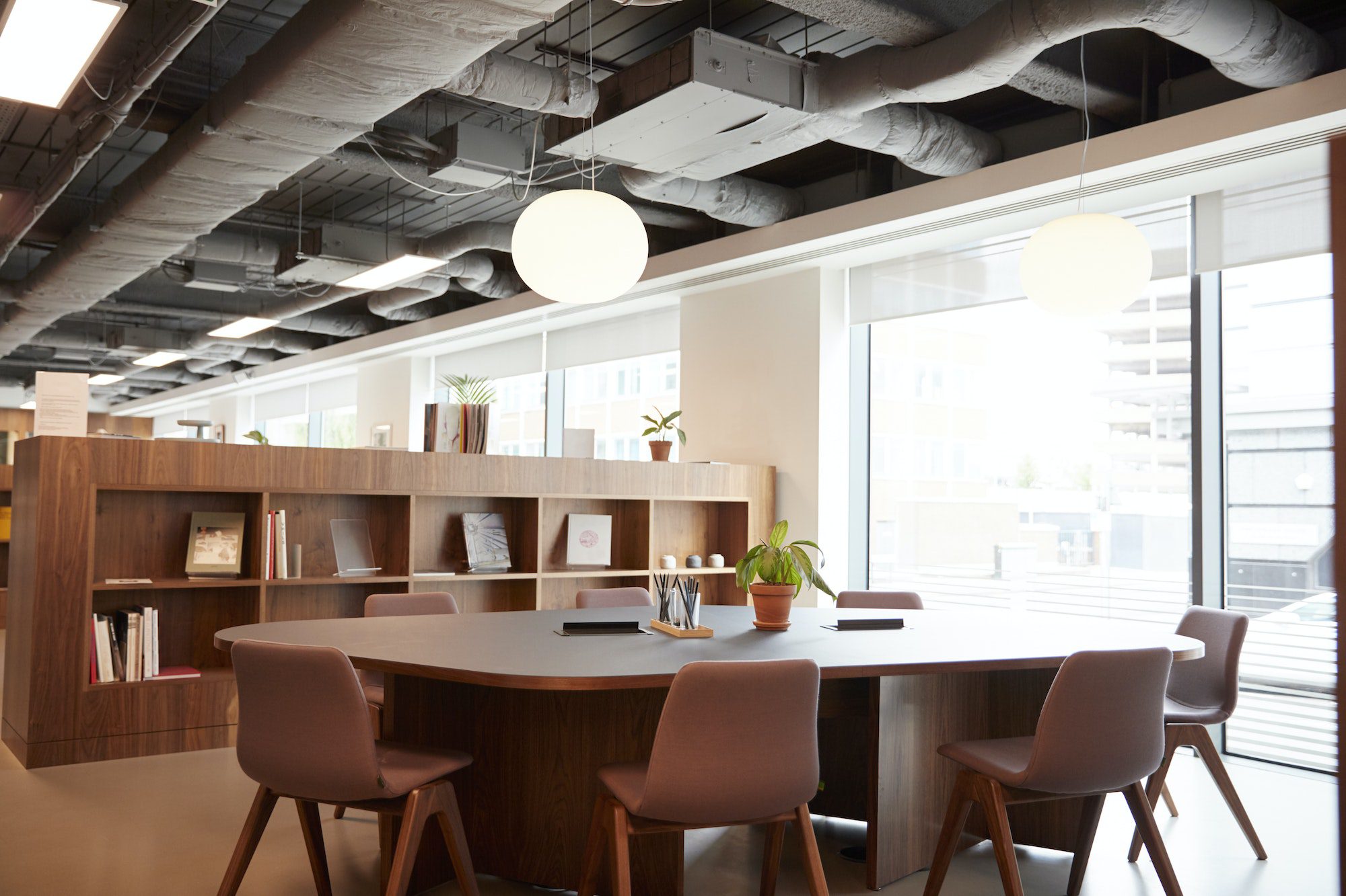 Chairs Around Table In Empty Modern Meeting Area Of Office