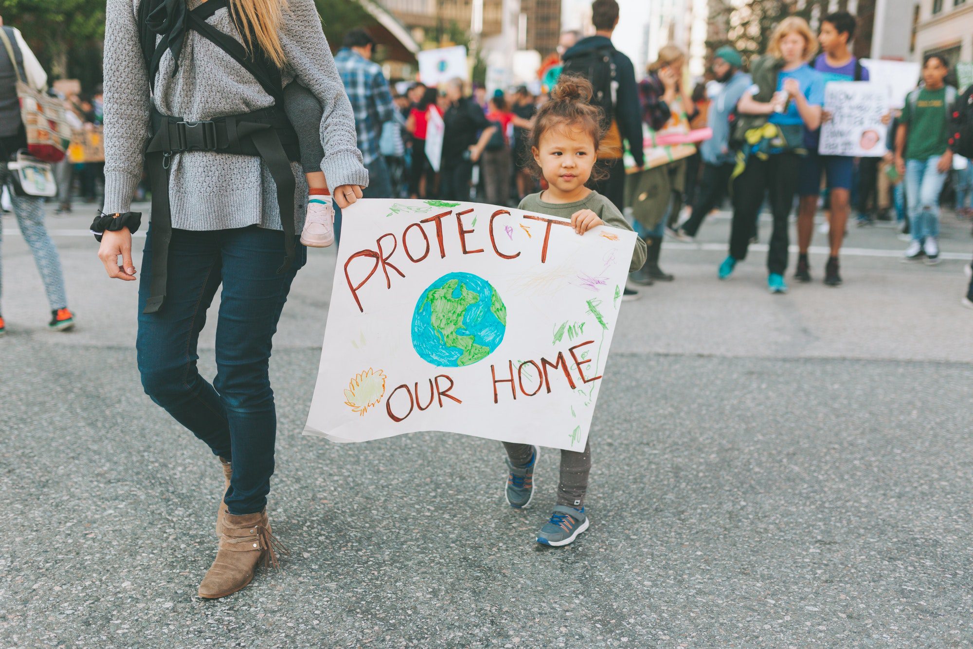 A little boy holding up a sign at a climate change rally.